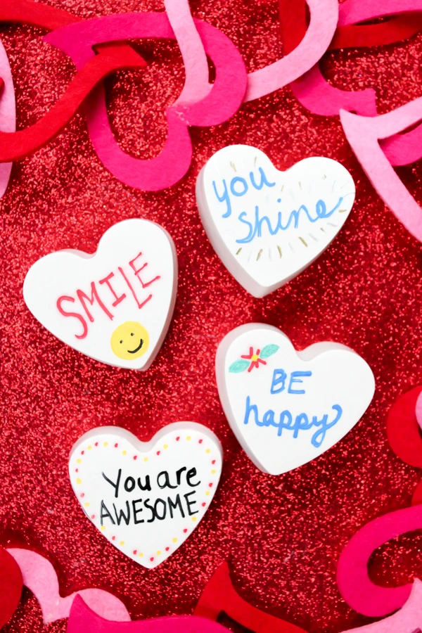 Heart-shaped kindness rocks are a fun spin on the kindness rock movement!  Learn how to make heart-shaped "rocks" in this tutorial!  Such a great Valentine's Day craft or everyday craft for kids!  #kindnessrocks  #kidscraft #Valentine